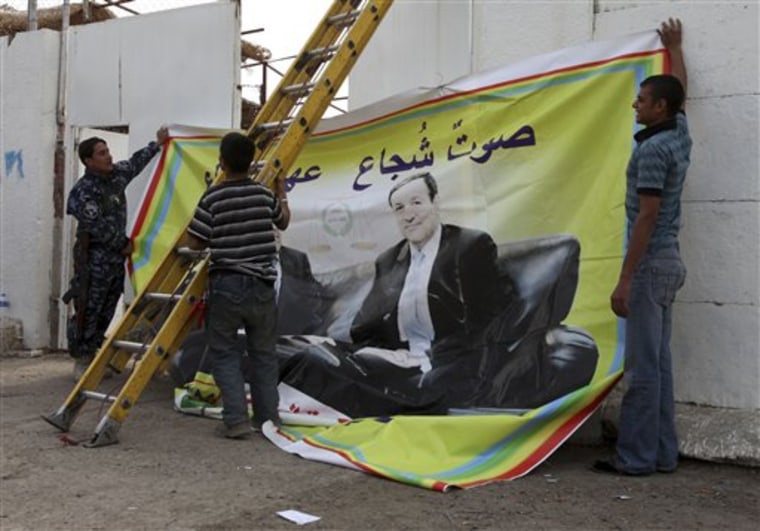 Workers install a campaign poster for candidate Ali al-Dabagh, the Iraqi government spokesman, a candidate with the State Coalition, in Baghdad, Iraq, Wednesday, Feb.17, 2010. Iraq's top Shiite cleric Grand Ayatollah Ali al-Sistani urged voters to turn out for parliamentary elections set for March 7 but is distancing himself from any particular coalition. (AP Photo/Karim Kadim)